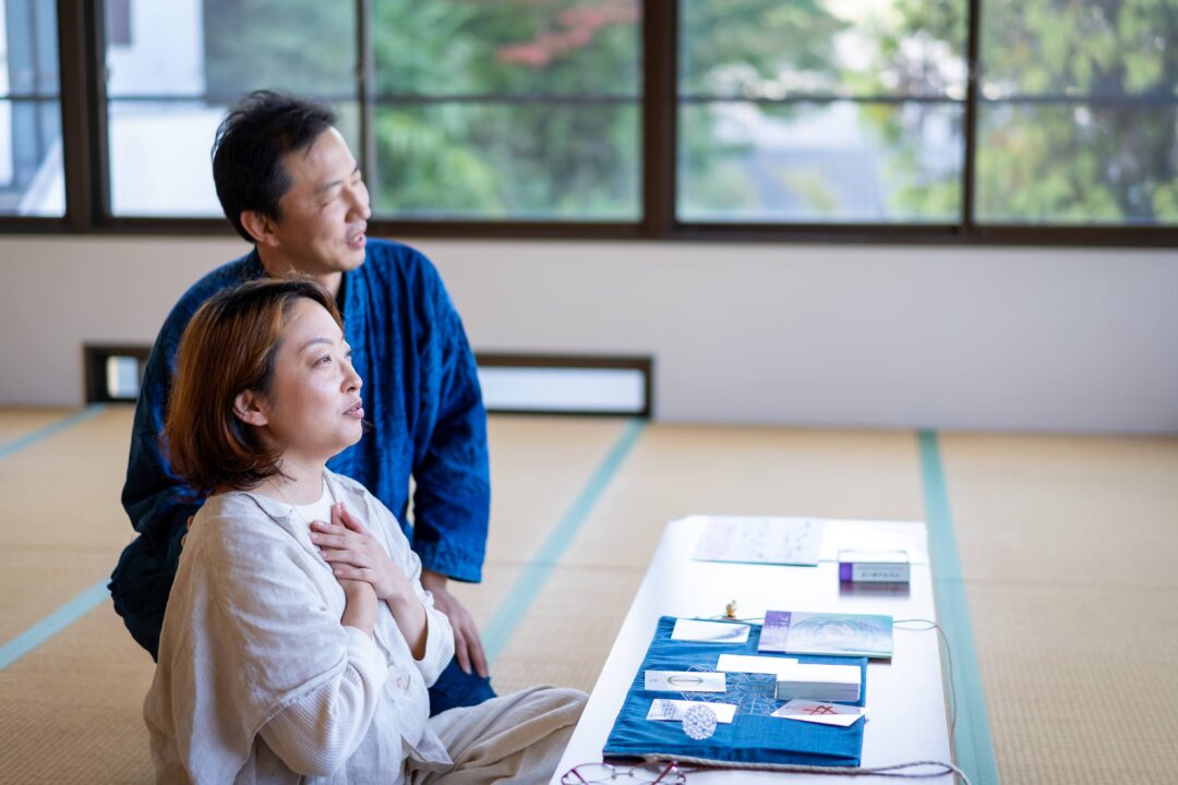 フトマニカード®の実践で胸に手を当て身体の感覚を確かめる様子